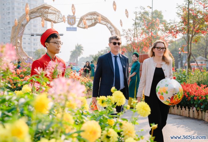 Ông Jonathan Baker - Trưởng đại diện Văn phòng UNESCO tại Việt Nam cùng phu nhân trải nghiệm đường hoa Home Hanoi Xuan. Ảnh: Tùng Đinh